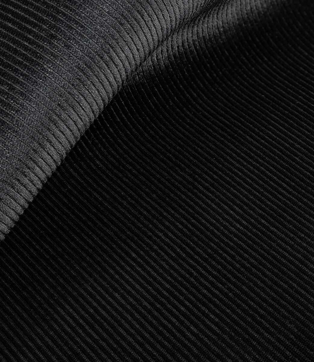Nahaufnahme von schwarzem Cordstoff mit diagonalen Rippen.