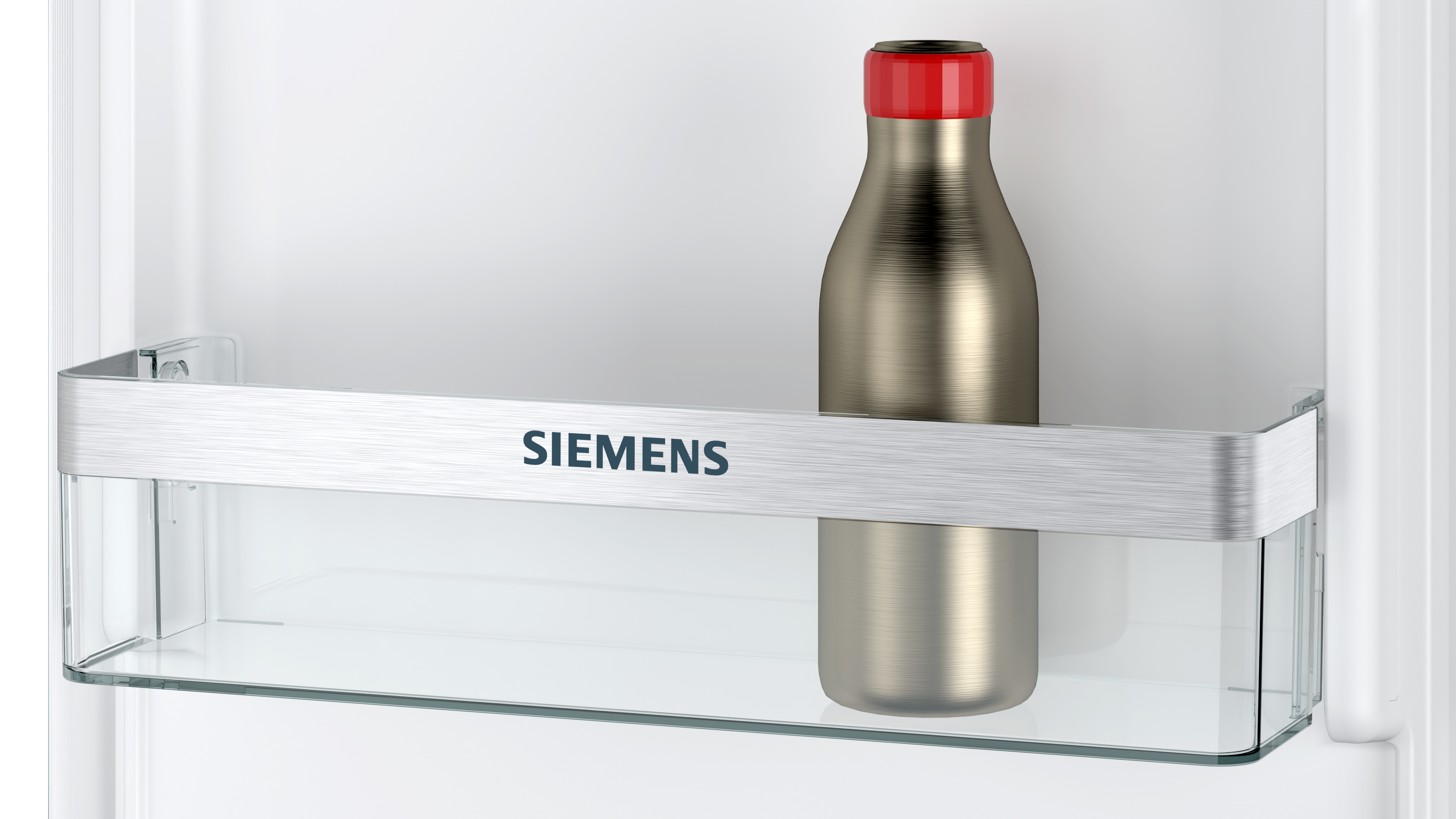 Silberne Flasche mit rotem Deckel im Kühlschrank.