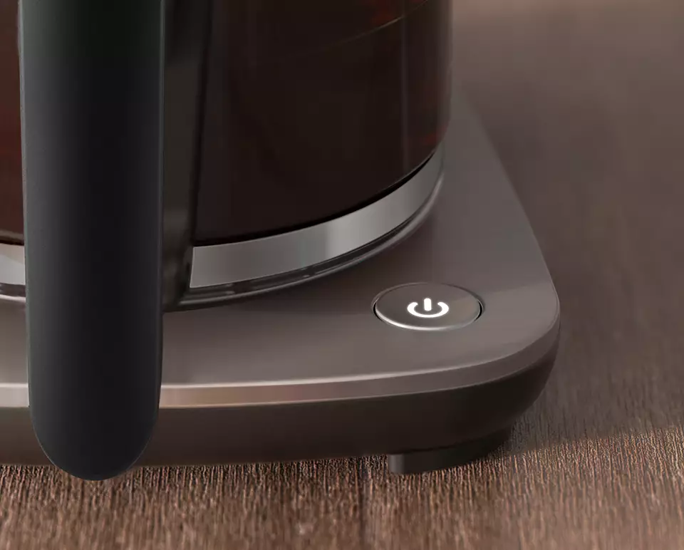 A close up of a power button on the base of a dark-colored kettle.