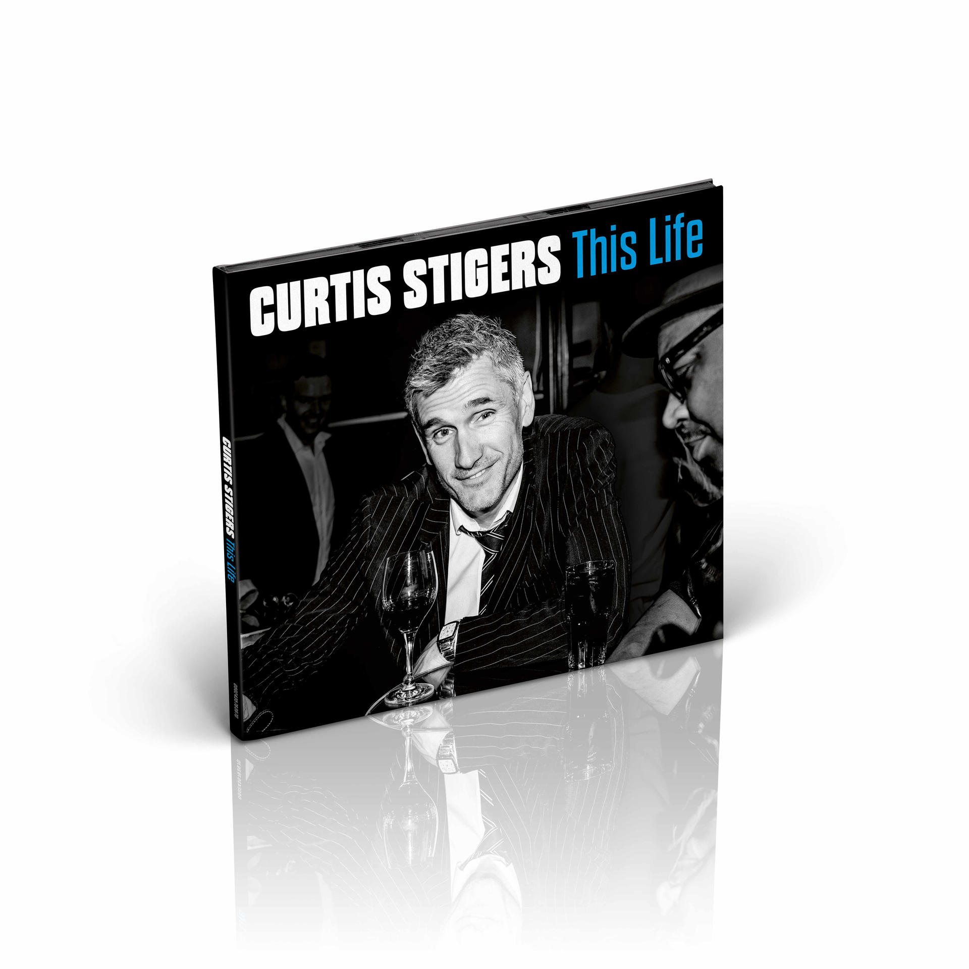 Boekomslag: Man in pak, wijnglas vasthoudend. Tekst: Curtis Stigers, This Life.