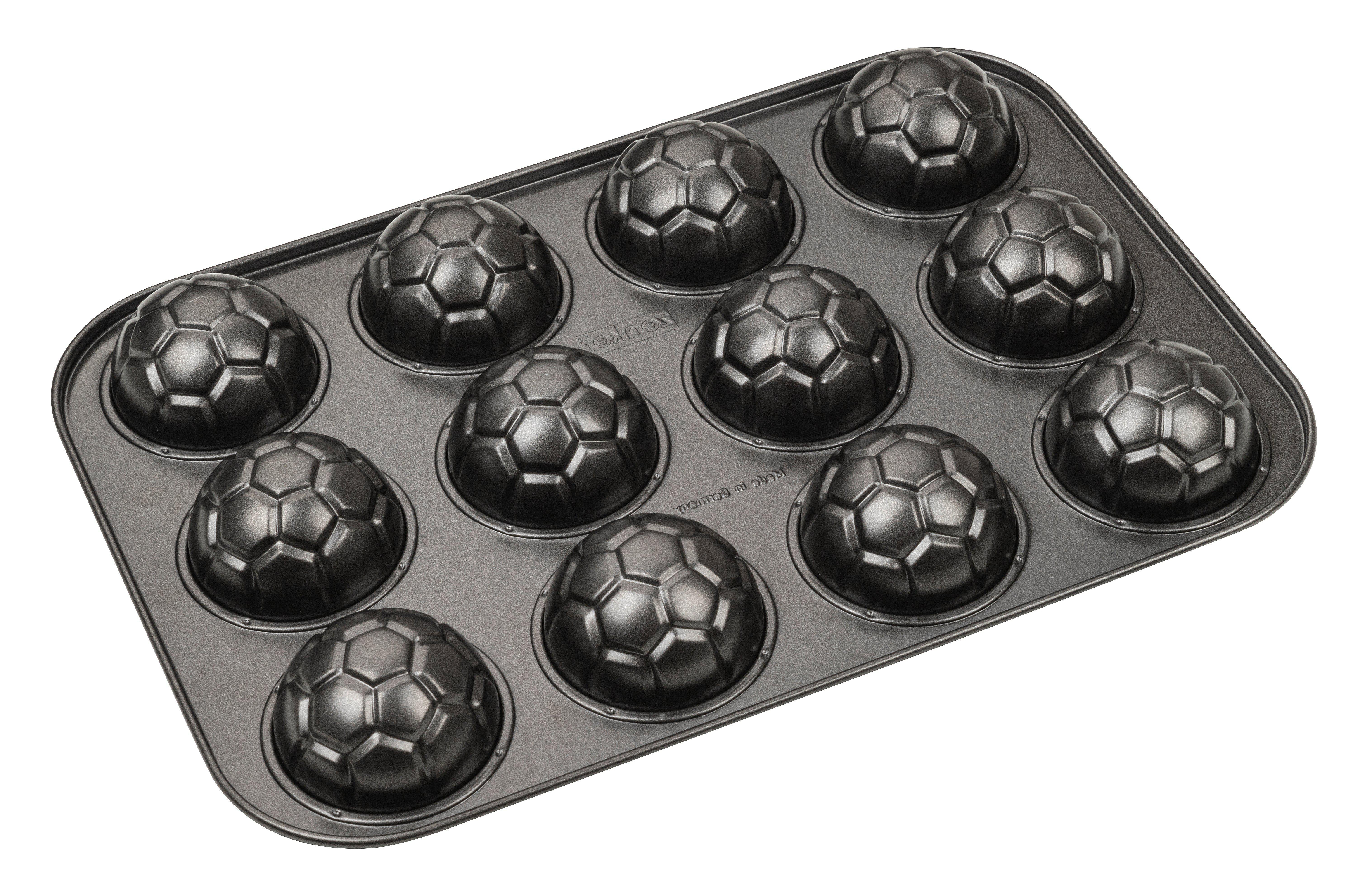 Dunkelgraue Backform aus Metall mit zwölf fußballförmigen Vertiefungen.