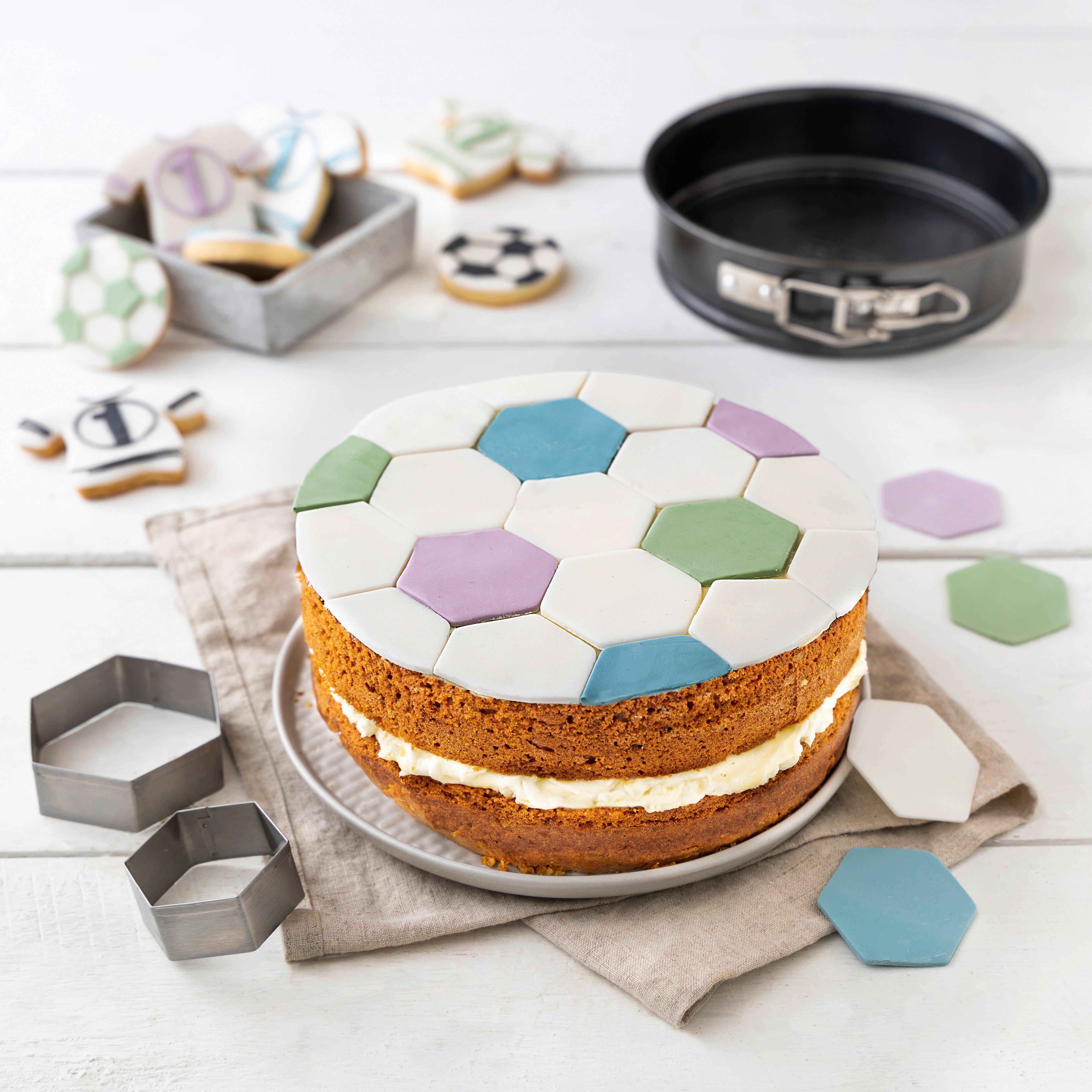 Ein Fußballkuchen mit Zuckerdekorationen und Keksformen.