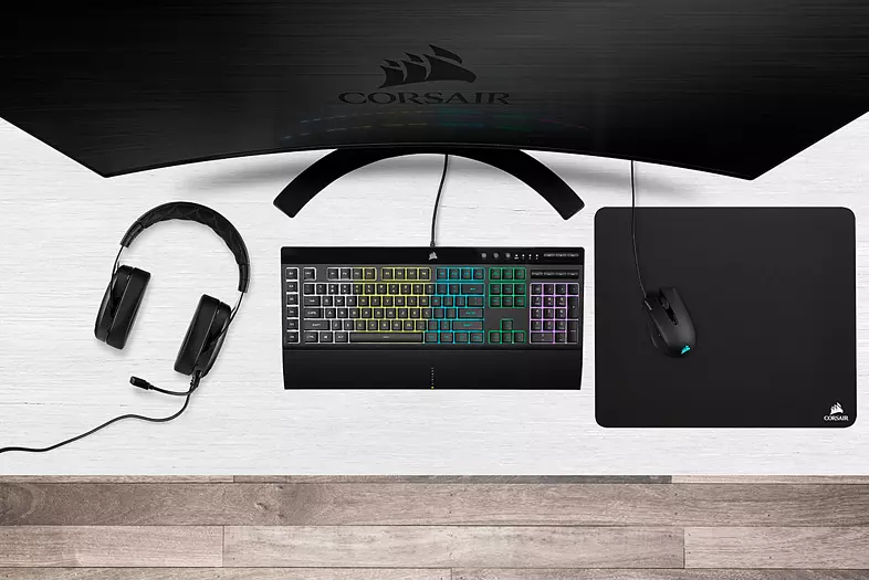 Schreibtisch-Setup mit Kopfhörern, Tastatur, Maus und Monitor.