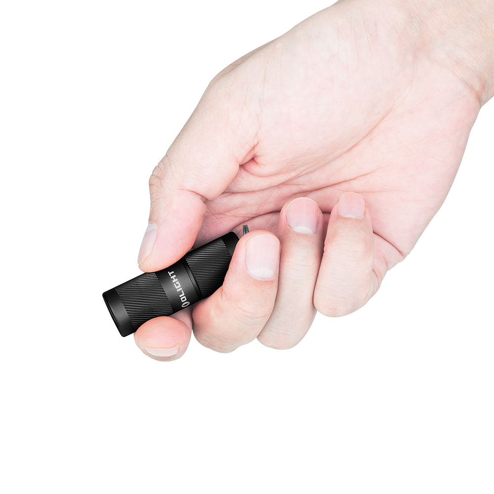 Eine Hand, die eine schwarze Olight-Taschenlampe vor weißem Hintergrund hält.