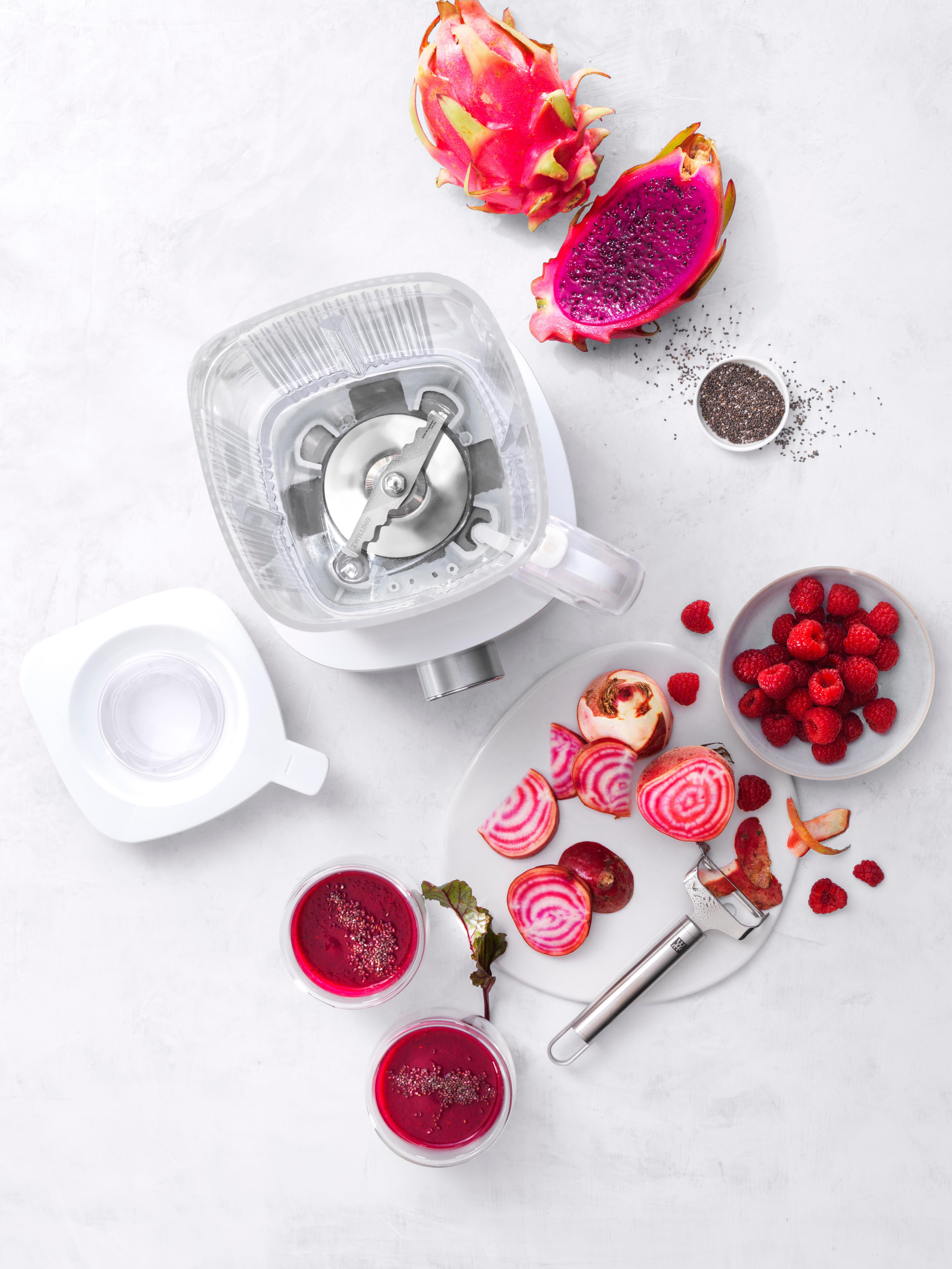 Draufsicht auf Mixer, Obst und Zutaten für einen Smoothie.