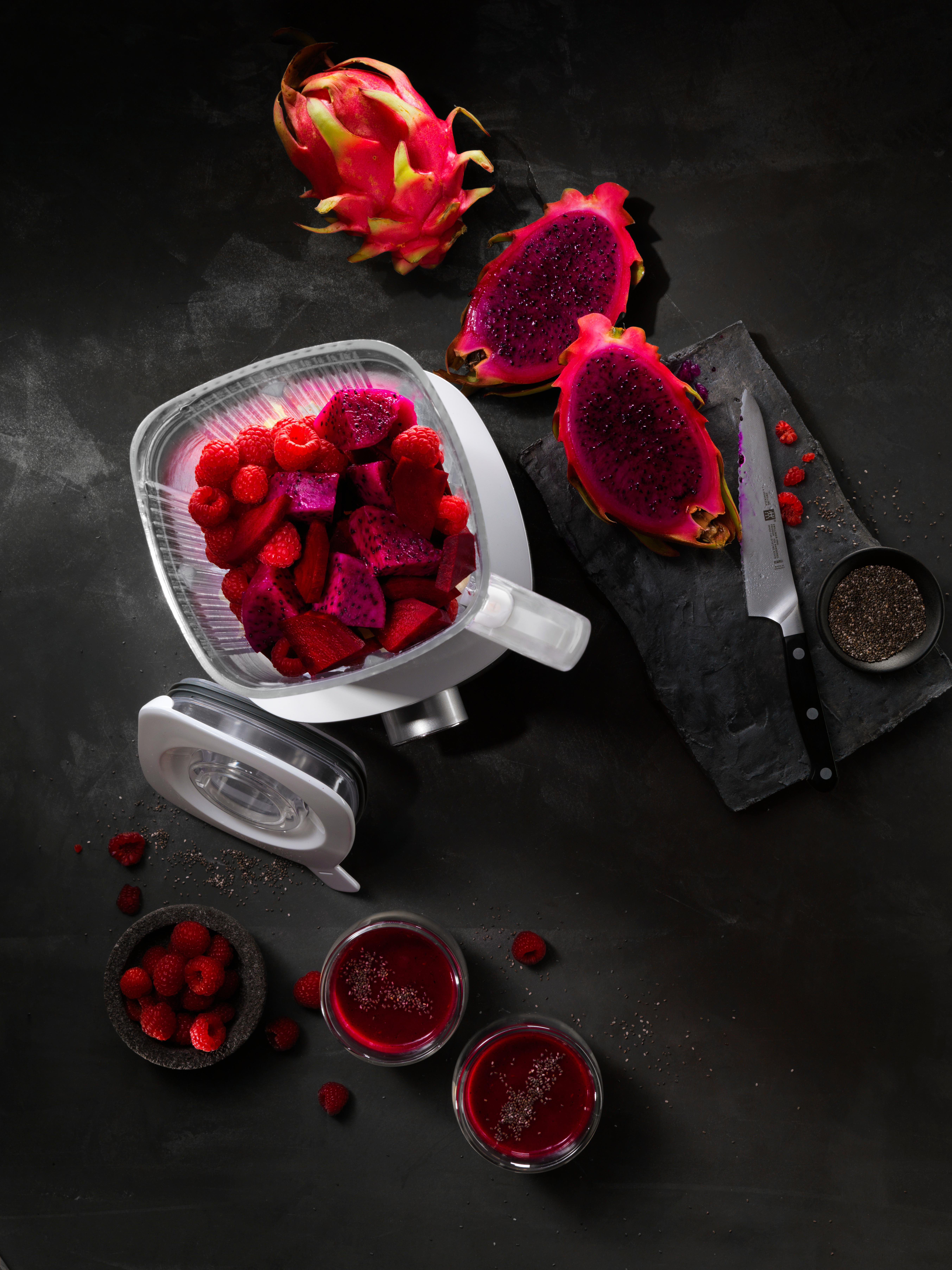 Draufsicht eines Mixers mit Drachenfrucht, Himbeeren und Smoothies.