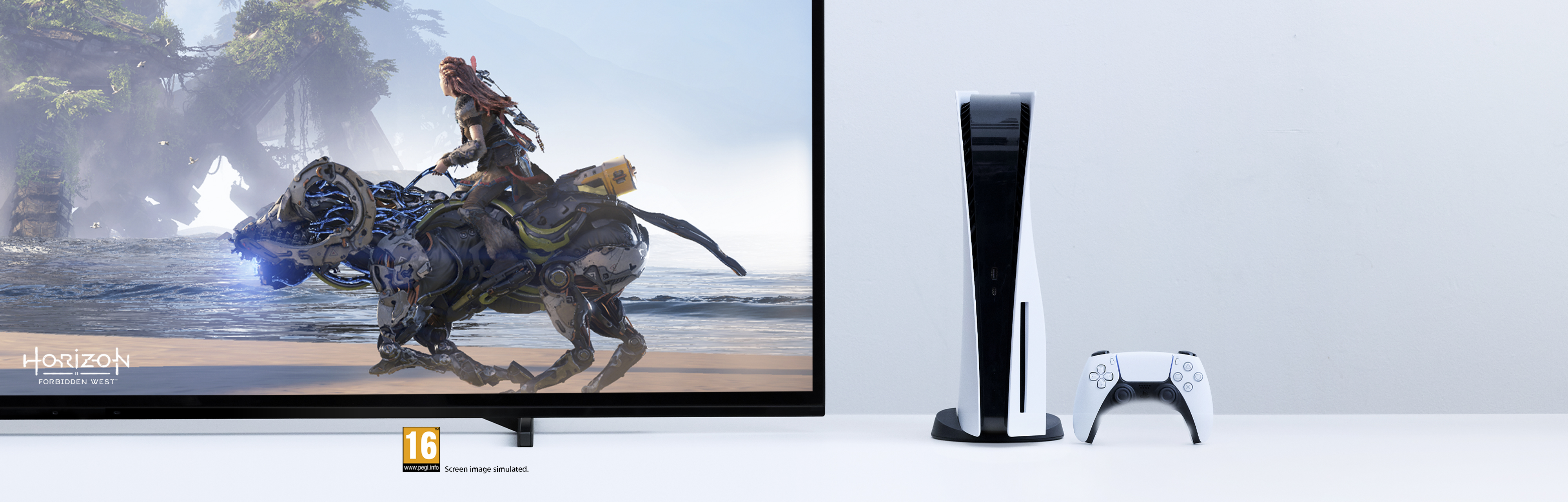 Aloy reitet auf einem Maschinenberg am Strand, neben einer PS5-Konsole und einem Controller.
