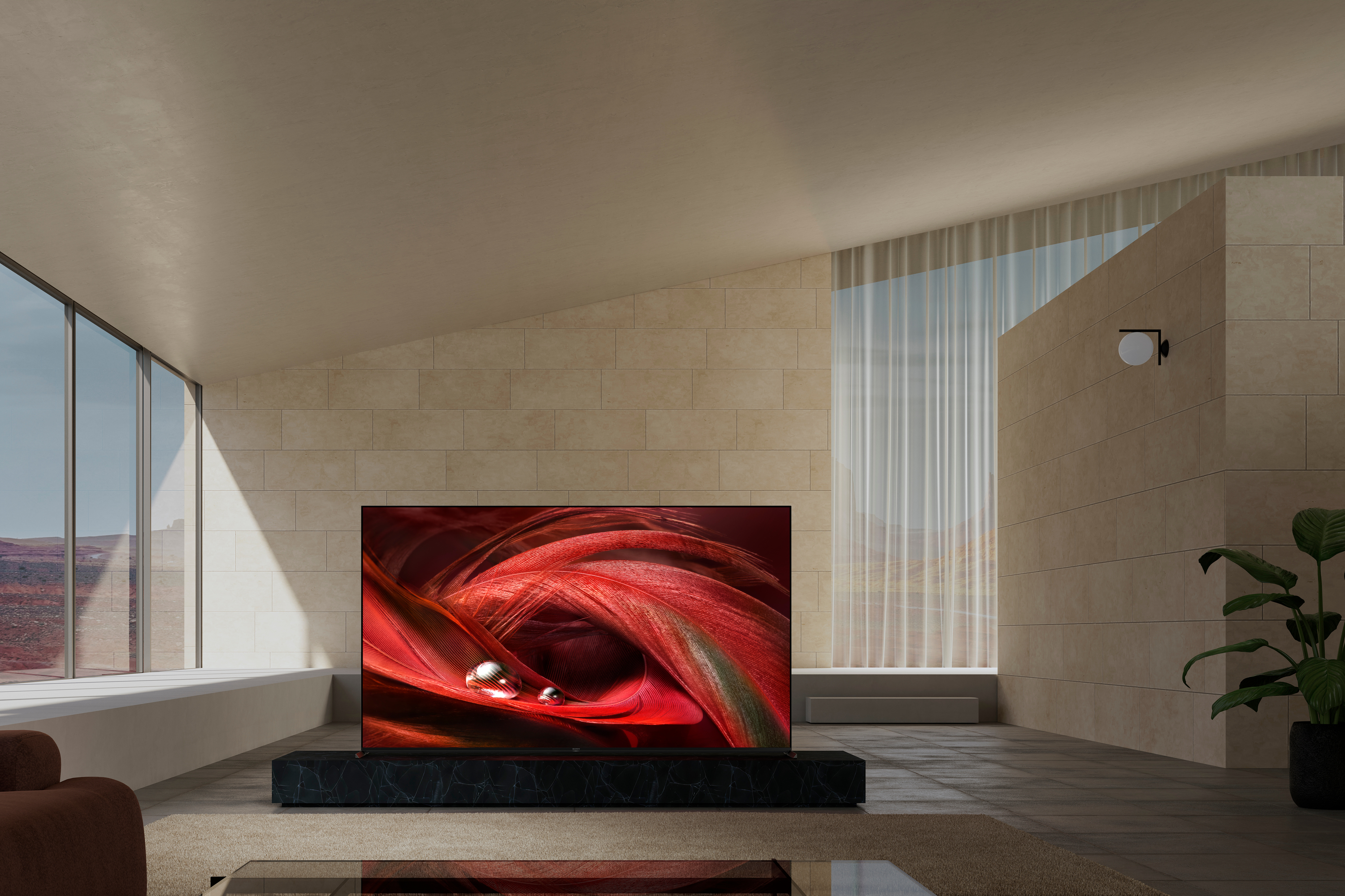Wohnzimmer mit großem Bildschirm-TV auf schwarzem Ständer und beigefarbener Wand.