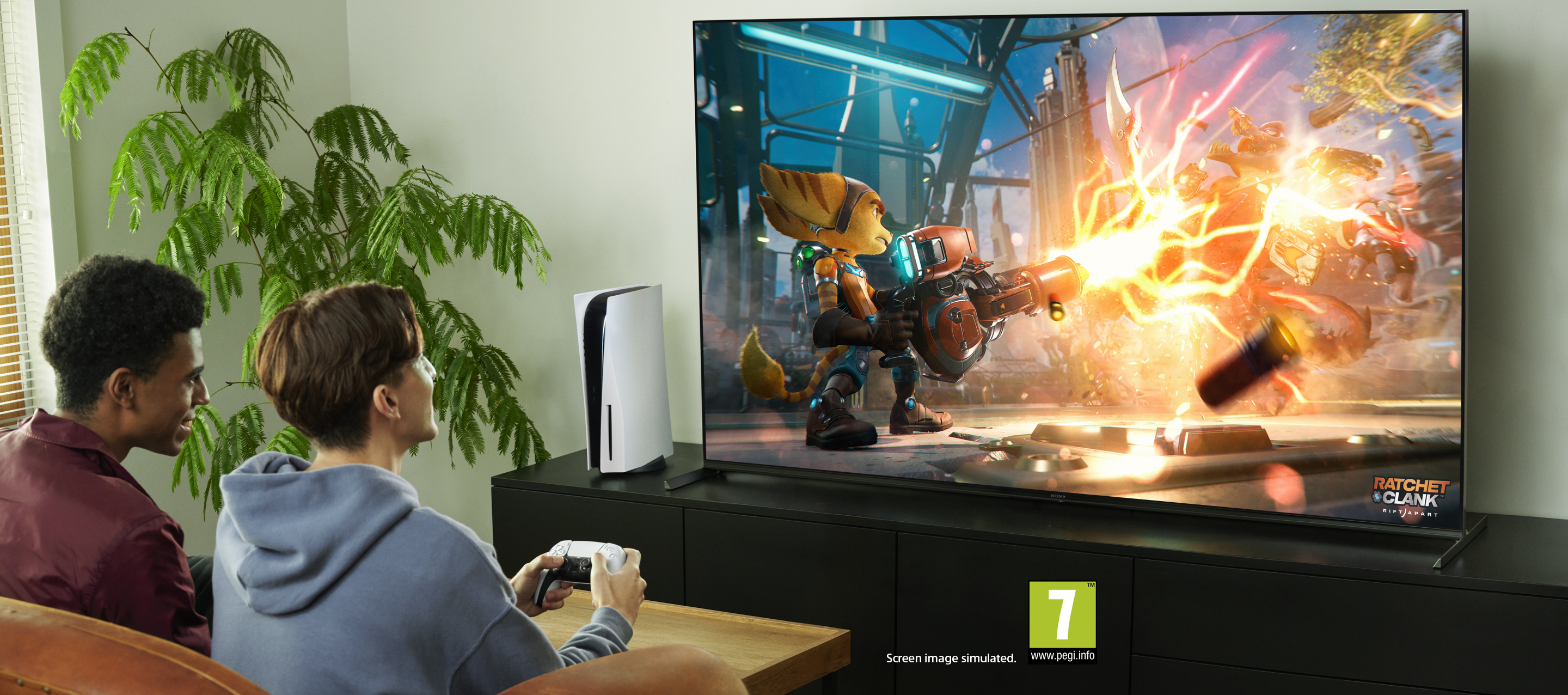 Zwei Männer spielen Videospiele auf einem Fernseher, PS5 daneben.