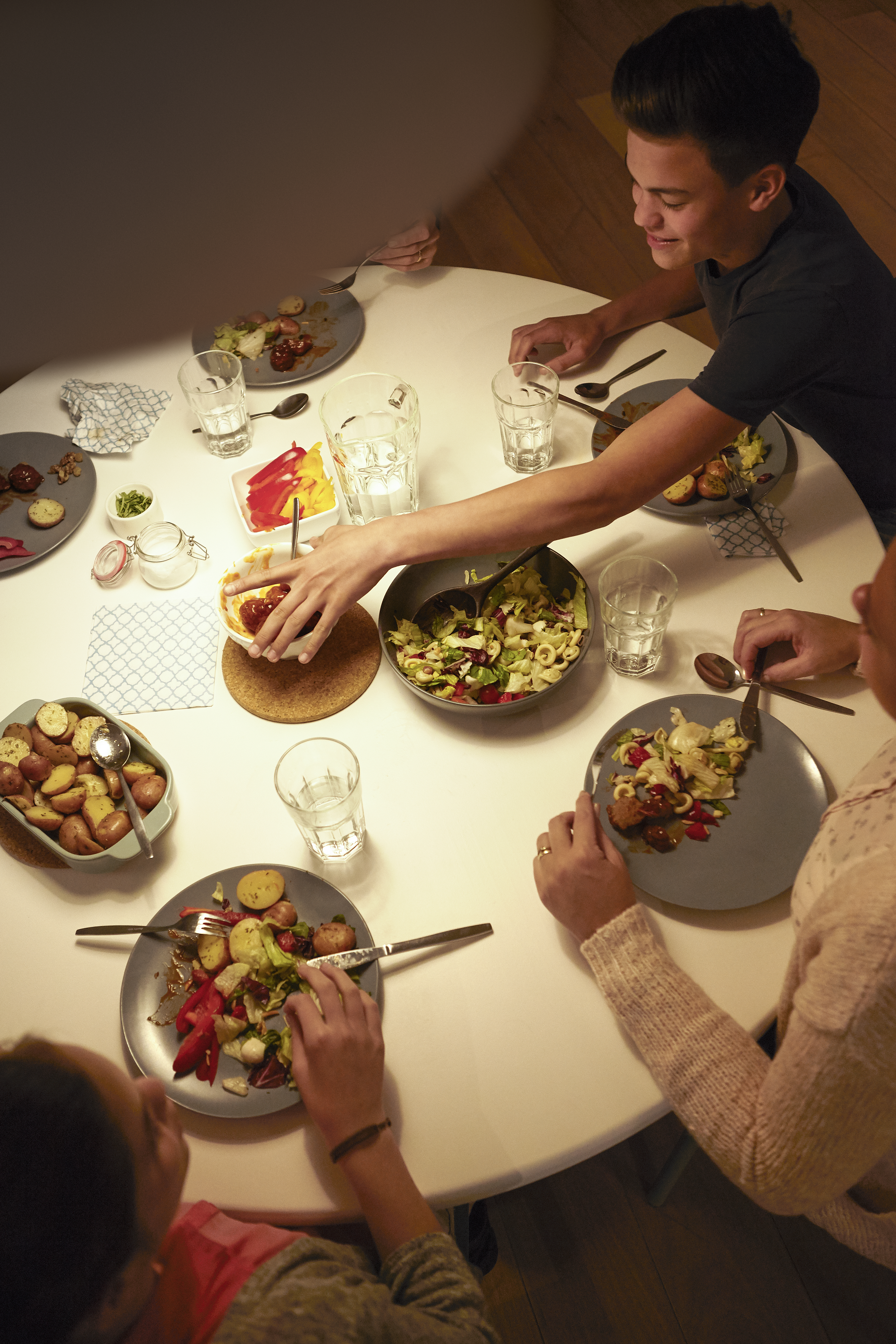 Eine Gruppe von Leuten sitzt an einem runden Tisch und isst eine Mahlzeit.