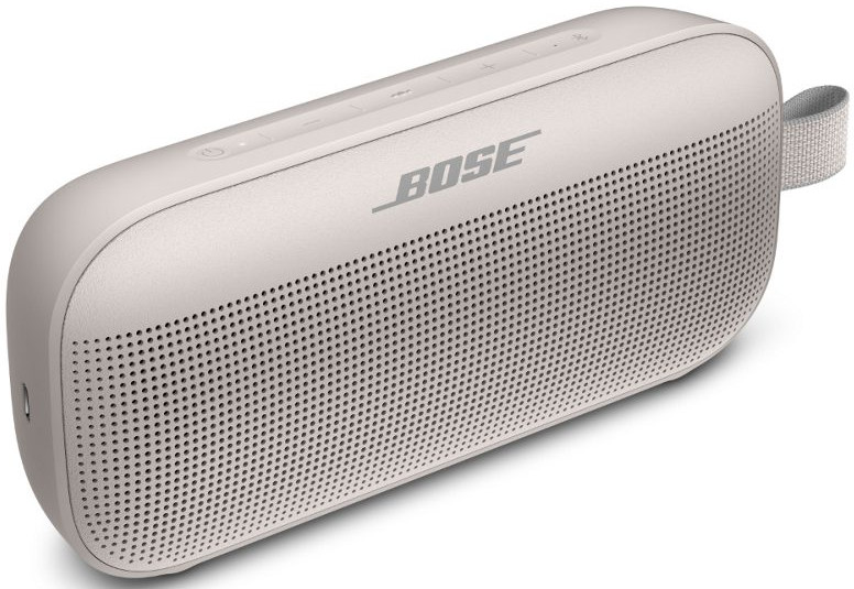 Un haut-parleur Bose de couleur claire avec une grille en tissu et une boucle de transport.