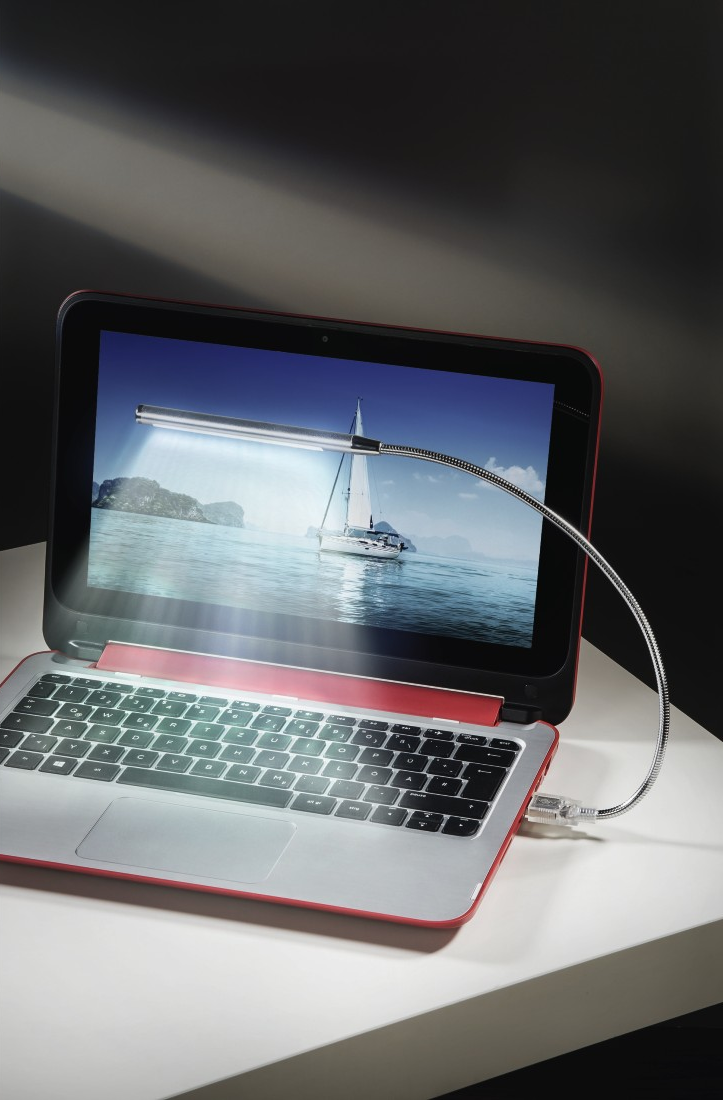 Laptop egy rögzített lámpával. A képernyő tengeri tájat mutat, fehér felületen.