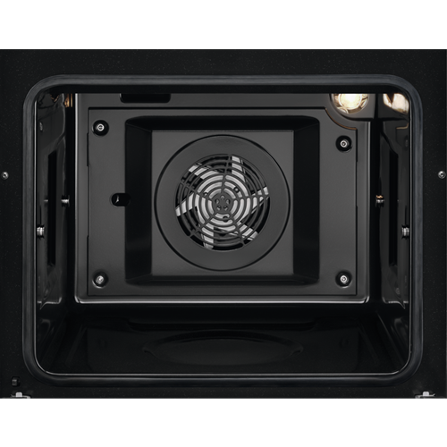 Inside of an oven. A fan is in the center and a light is at the top right corner.