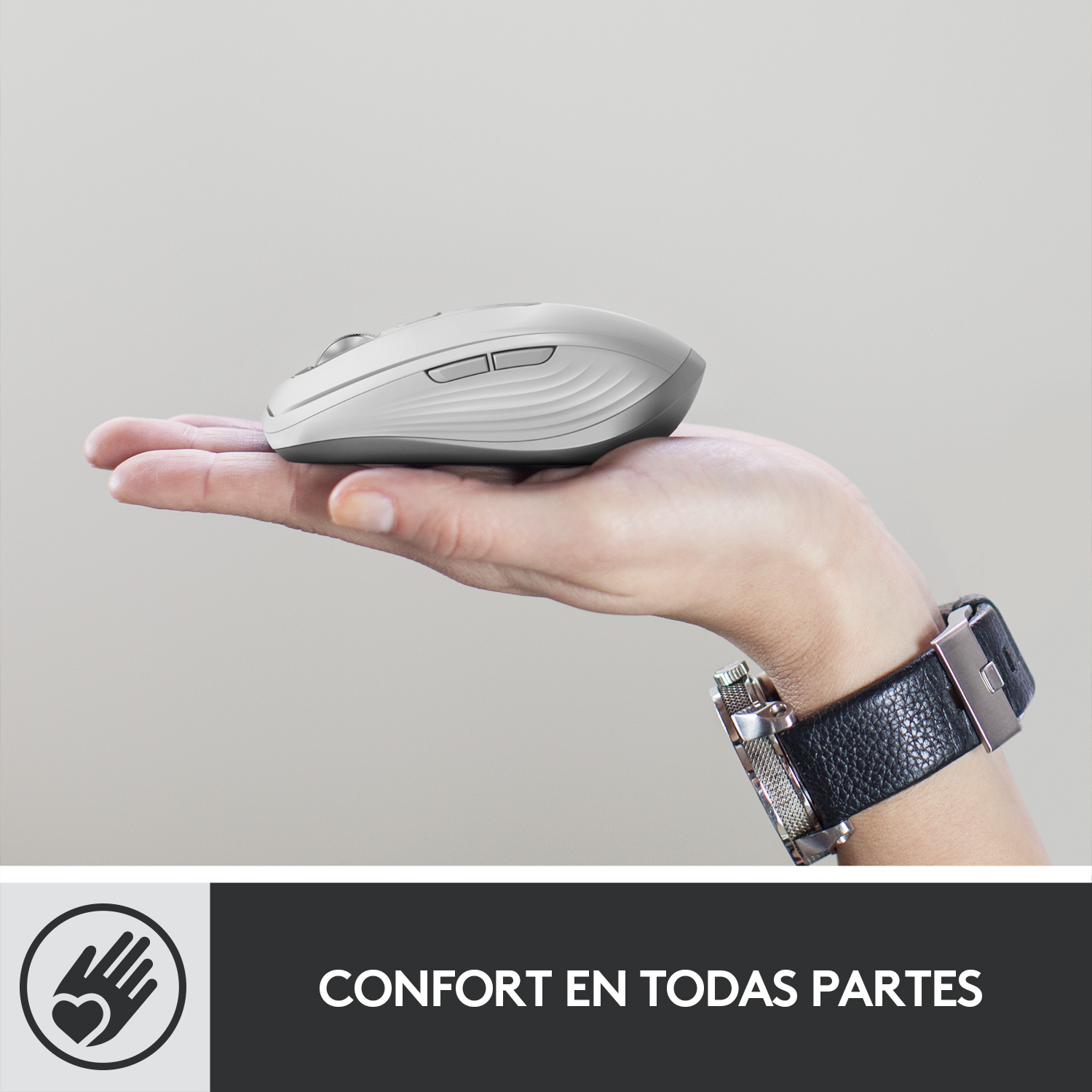 Mano sosteniendo un ratón blanco. Detalles grises y negros. Fondo gris, reloj en la muñeca.