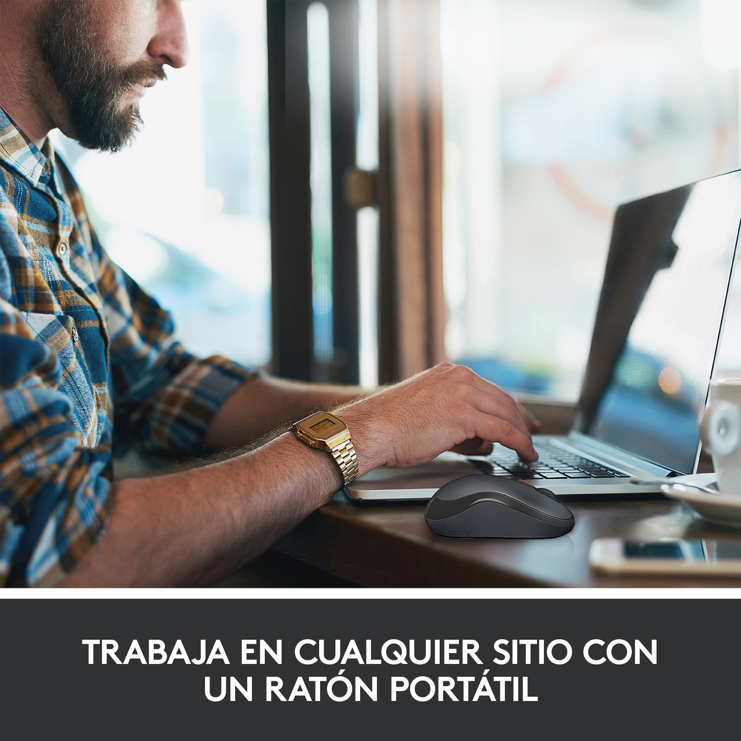 Un hombre usando un portátil con un ratón negro sobre una mesa de madera. El texto dice: "Trabaja en cualquier sitio con un ratón portátil".