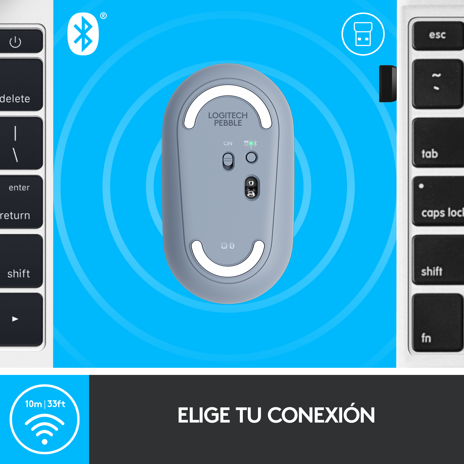 Un ratón Logitech Pebble gris sobre una superficie azul, cerca de un teclado. El ratón tiene un interruptor de encendido/apagado y un logotipo de Bluetooth.