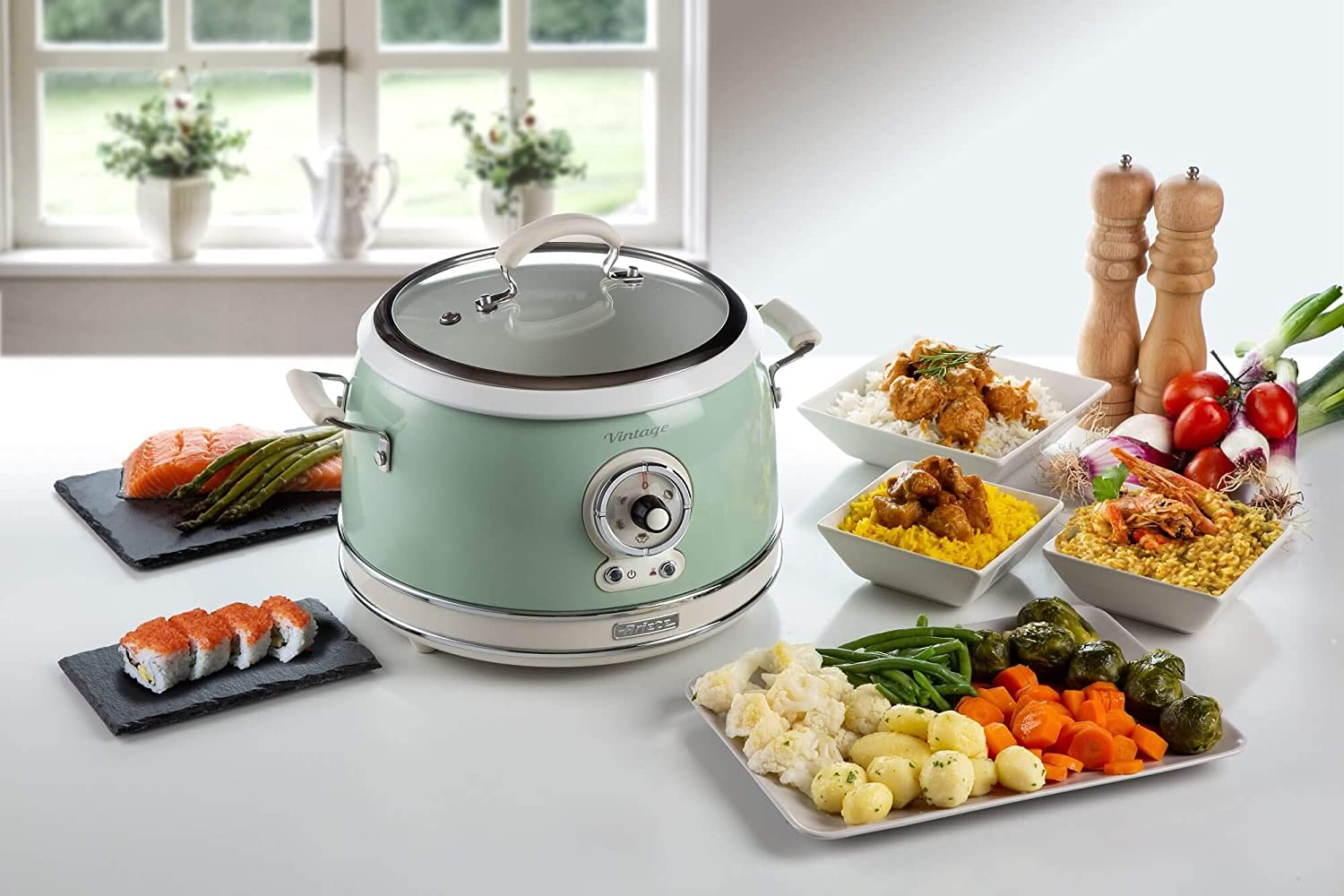 Une casserole vert menthe de style vintage avec de la nourriture autour, dont du riz, des légumes et des sushis.