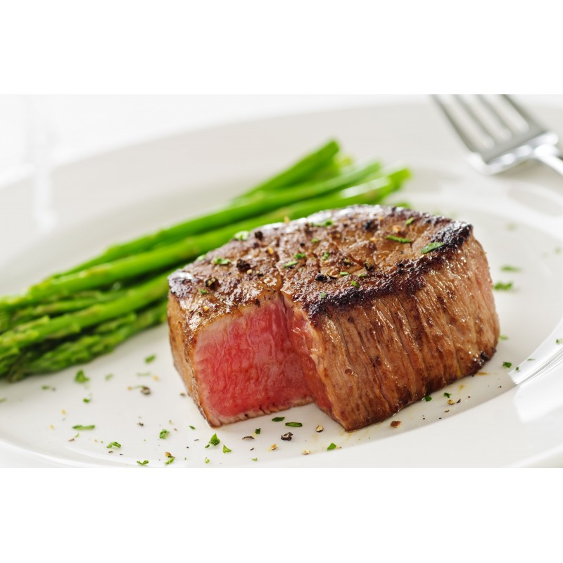Medium-rare steak with asparagus on a white plate.