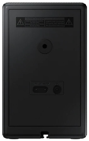 Panneau arrière d'un appareil noir avec cercle central et connecteurs.