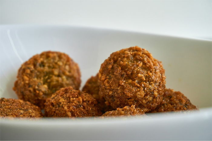 Close-up van falafel in een witte kom, textuur zichtbaar.