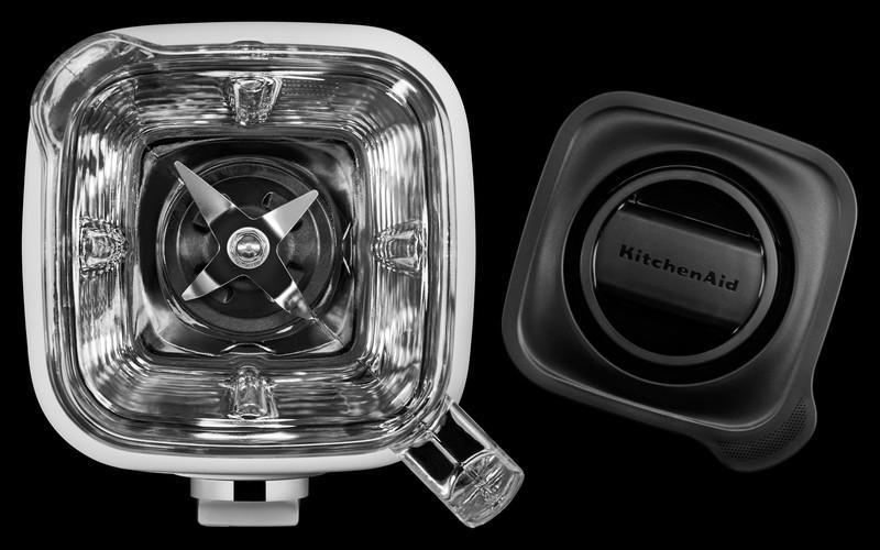 Draufsicht auf einen KitchenAid-Mixerbehälter und -Deckel auf schwarzem Hintergrund.