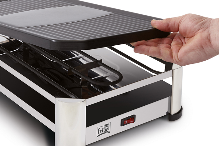 Hand lifting the top part of a raclette grill.
