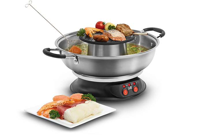 Een roestvrijstalen hot pot met een grill, en een bord met eten ervoor.