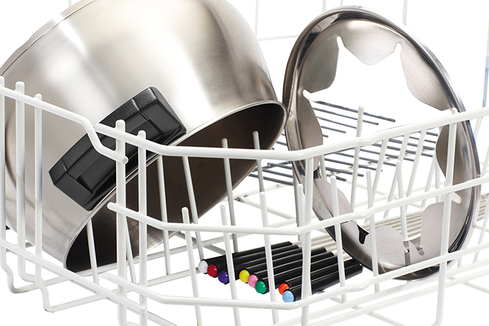 Dishwasher rack with a stainless steel pot, lid, and colorful markers.