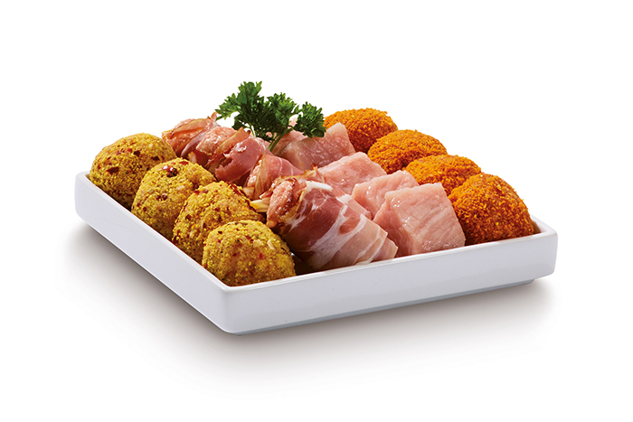 A tray of various cooked meats: meatballs, bacon-wrapped items, and cubed meat pieces.