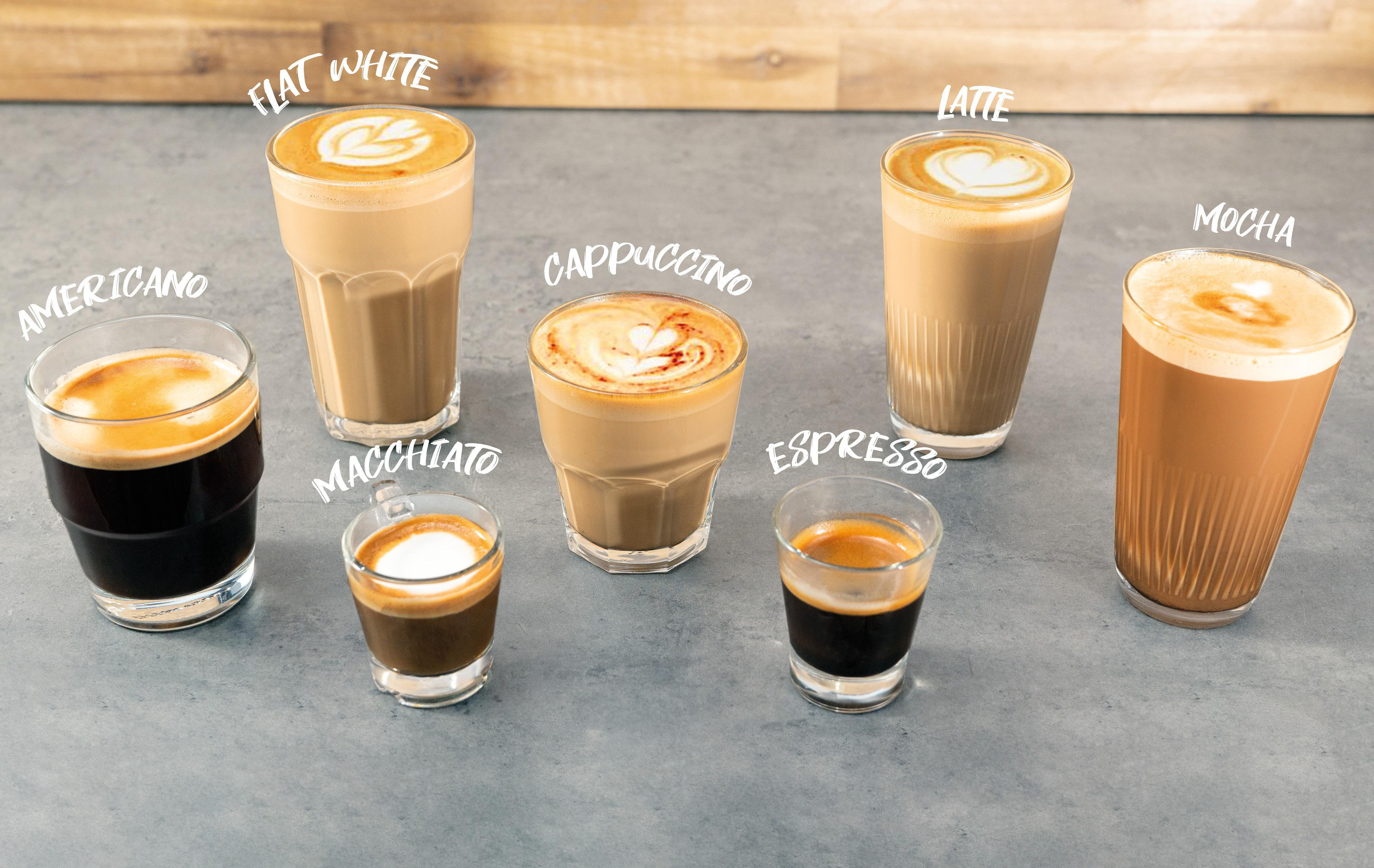 Verschiedene Arten von Kaffeegetränken in Gläsern auf einer grauen Oberfläche, jeweils mit Etikett.