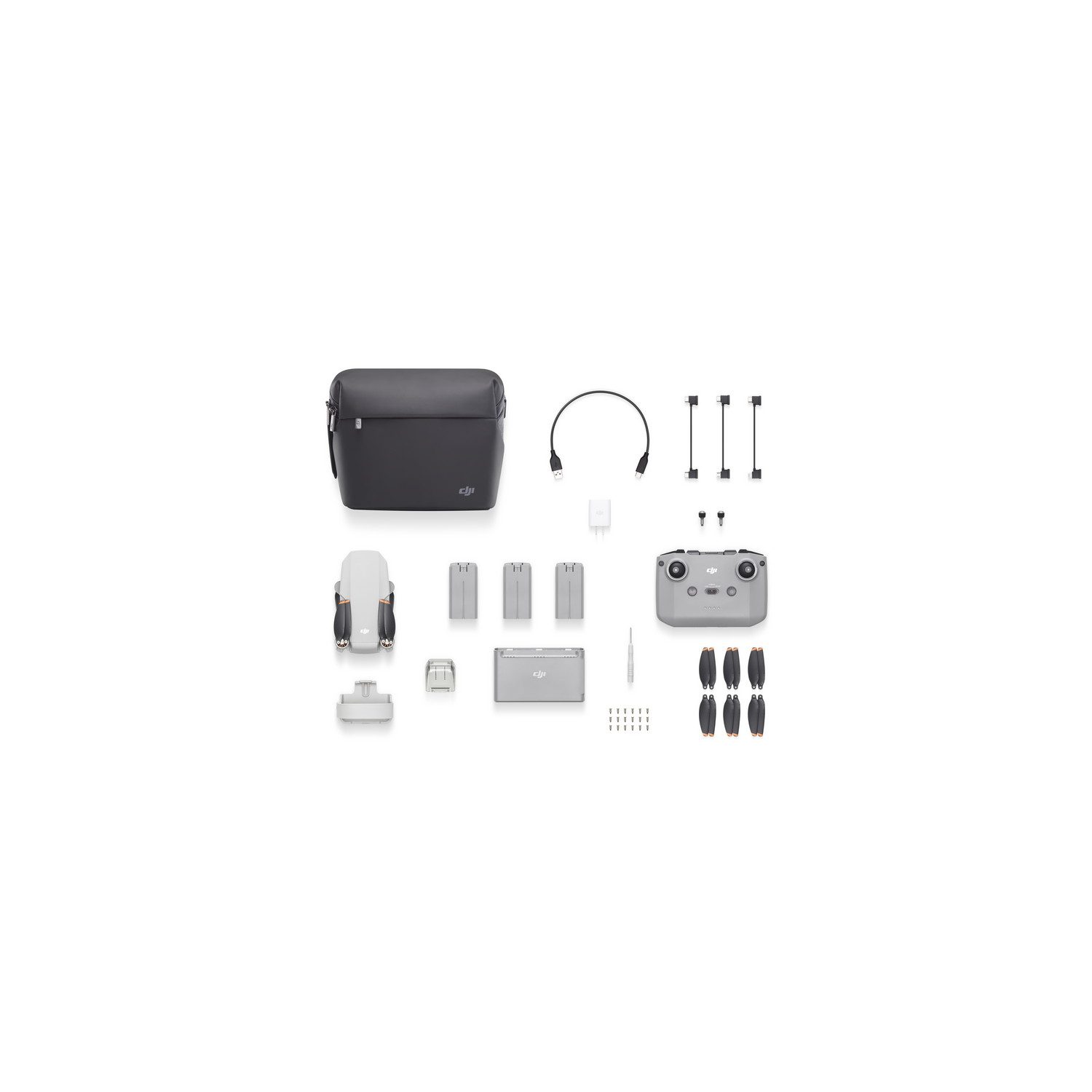 Kit de drones con dron, baterías, cargador, control remoto y accesorios, todo ordenado.
