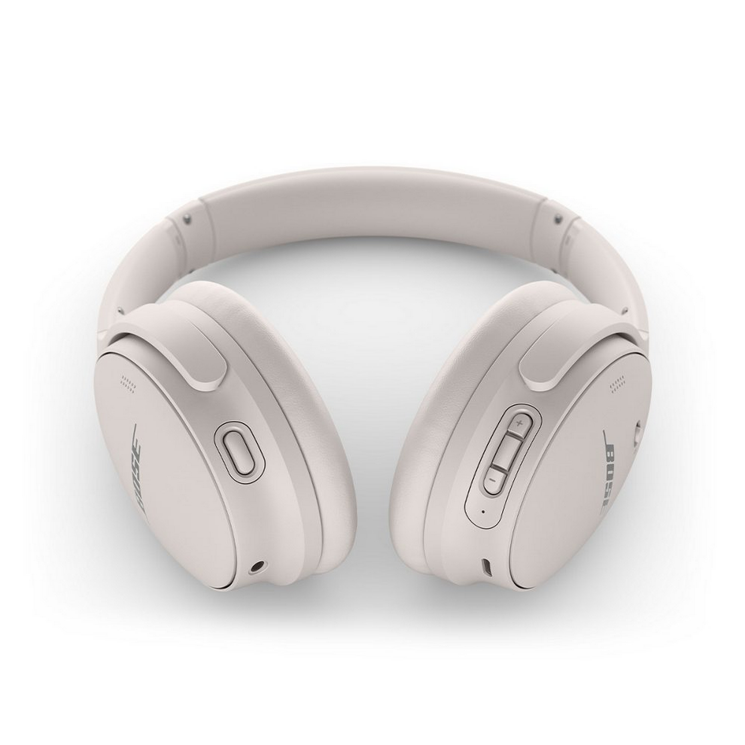 Auriculares Bose blancos, sobre una superficie blanca, con botones y un logotipo visible.