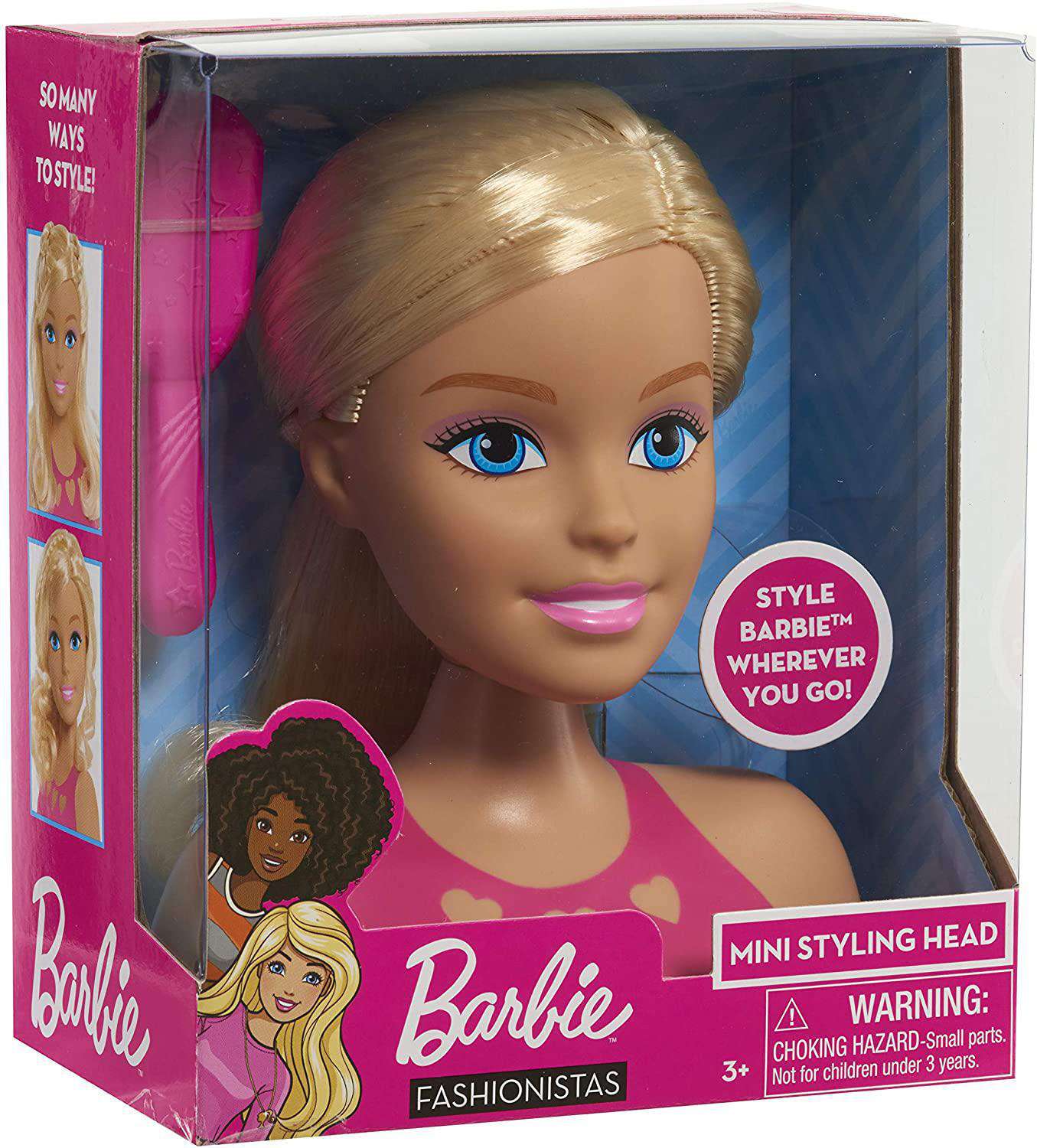 Barbie-Stylingkopf in einer Box. Der Kopf ist blond mit rosa Lippen und blauen Augen.