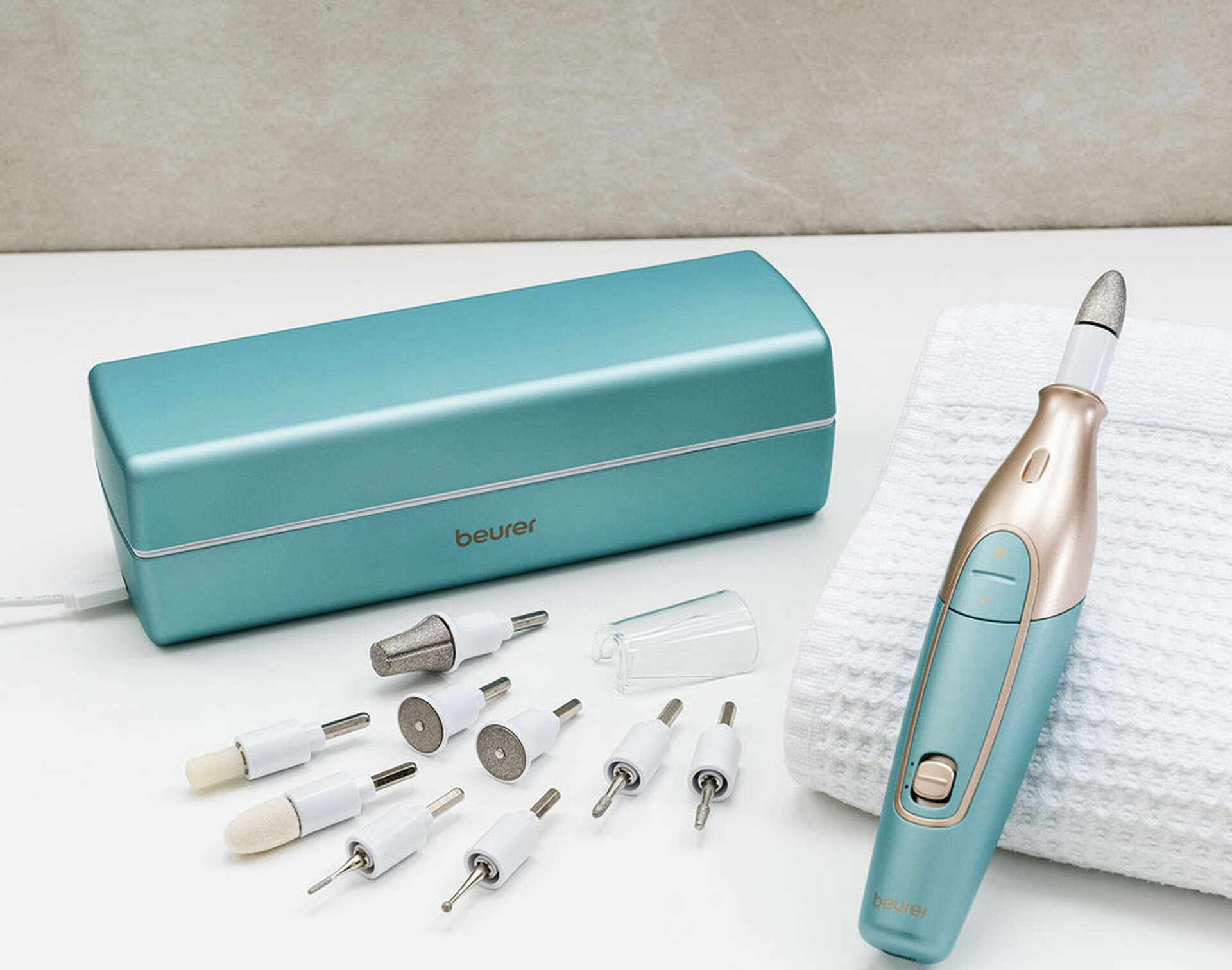 Un set per manicure con vari strumenti e una custodia turchese, uno strumento per manicure è in primo piano.