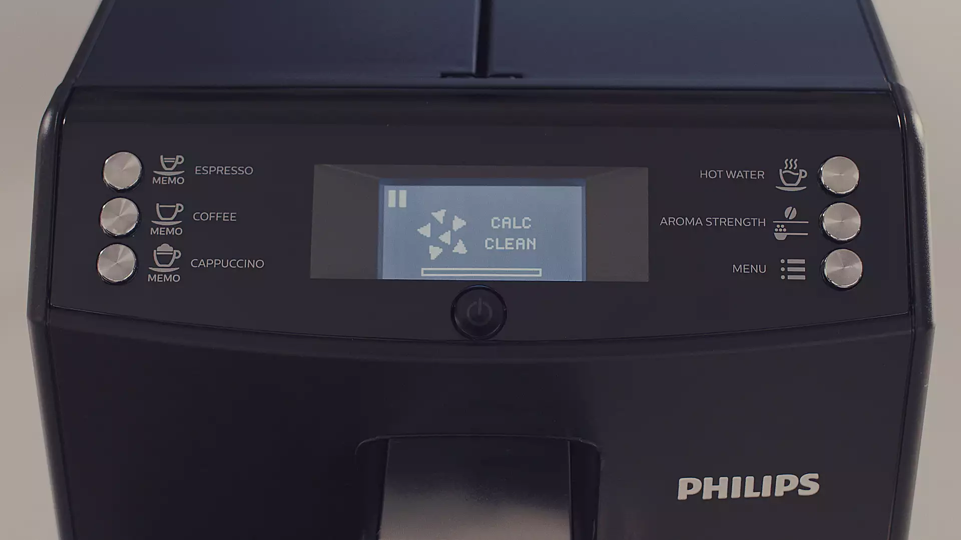 Gros plan sur l'écran d'une machine à café noire affichant les options 'CALC' et 'CLEAN'.