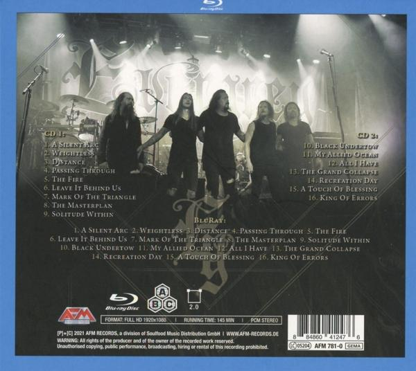 Rückseite einer Blu-ray-Disc-Hülle mit Albumcover einer Band. Text und Bilder auf dunklem Hintergrund.