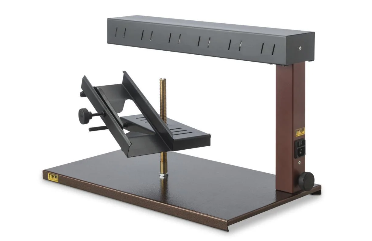 Raclette-Grill mit schwarzem Heizelement über einem geneigten Käsehalter.