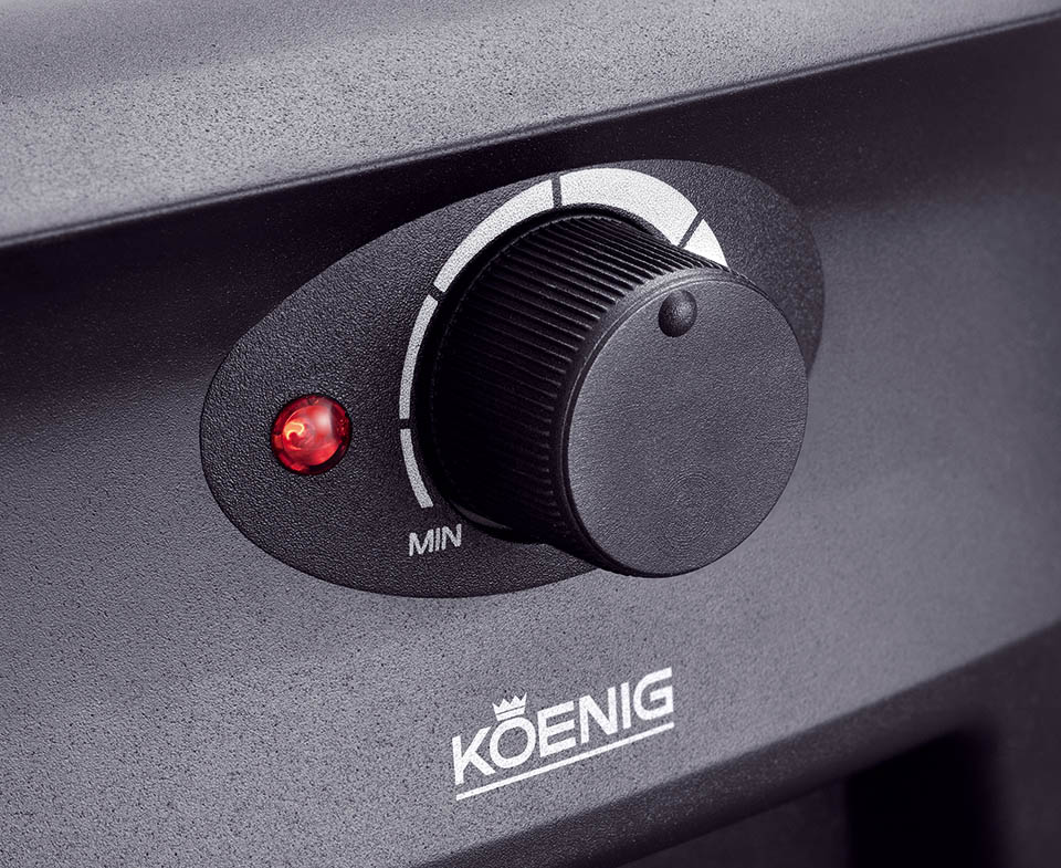 Ein schwarzer Bedienknopf mit rotem Licht und dem Koenig-Logo.