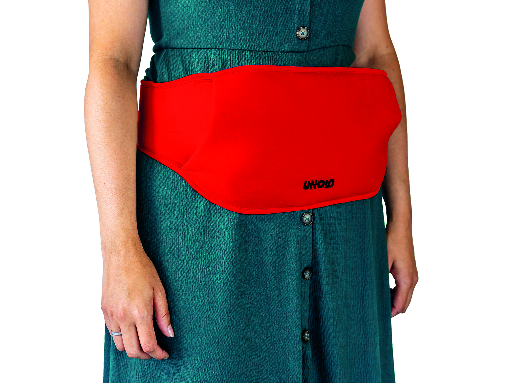 Eine Person, die ein grünes Kleid trägt, mit einem roten Heizkissen um die Taille.