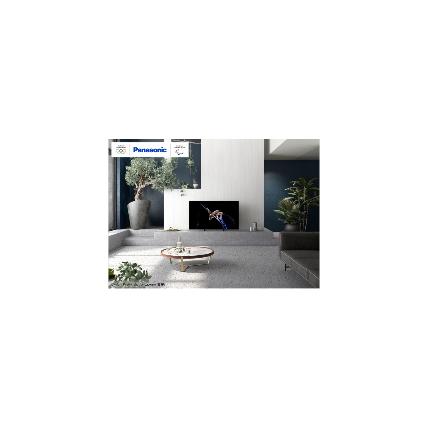 Salón con televisor, mesa de centro redonda y sofá.