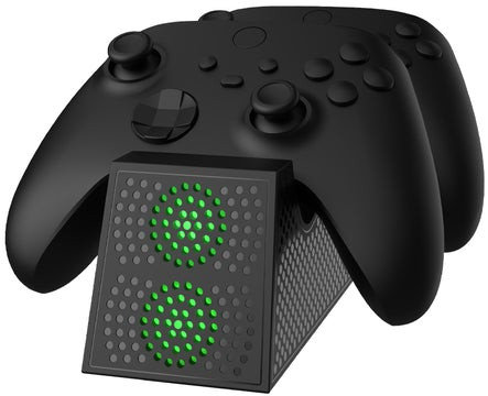 Twee zwarte Xbox-controllers op een oplaadstation met groene lichten. Het station heeft een roosterontwerp.