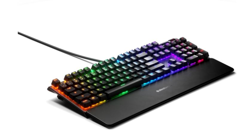 RGB aydınlatmalı ve bilek desteği olan siyah bir SteelSeries Apex Pro TKL oyun klavyesi.