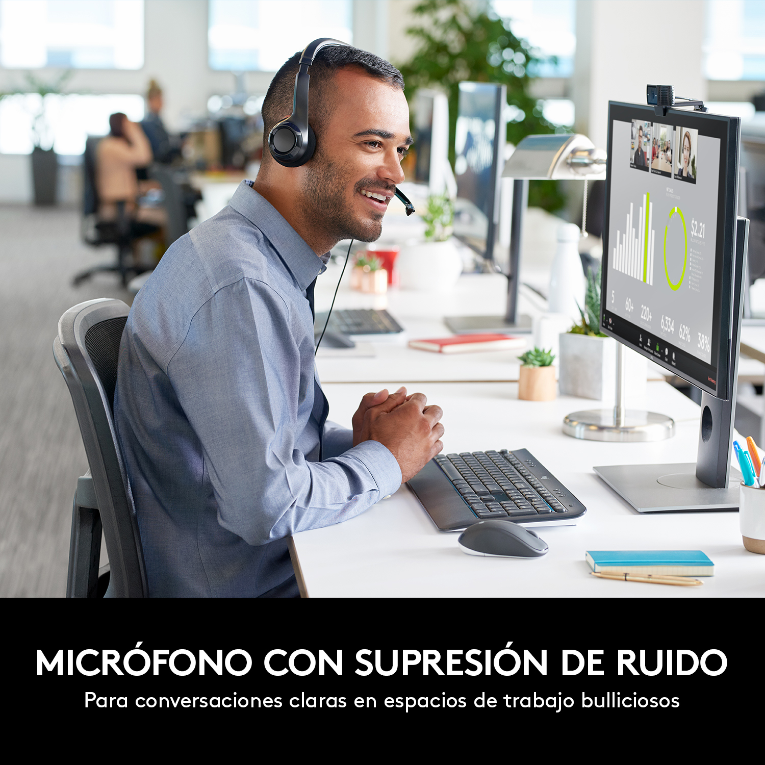 Hombre con auriculares y micrófono. Sonríe a la pantalla de una computadora.