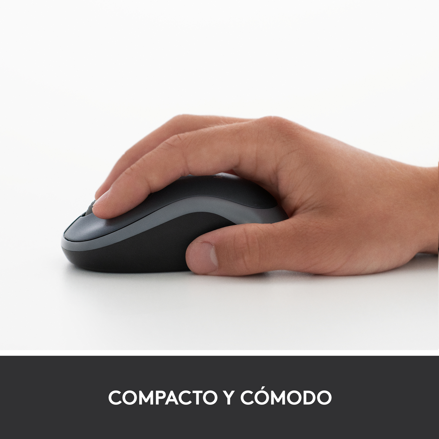 Una mano sosteniendo un ratón Logitech negro y gris sobre una superficie blanca, con texto en la parte inferior.