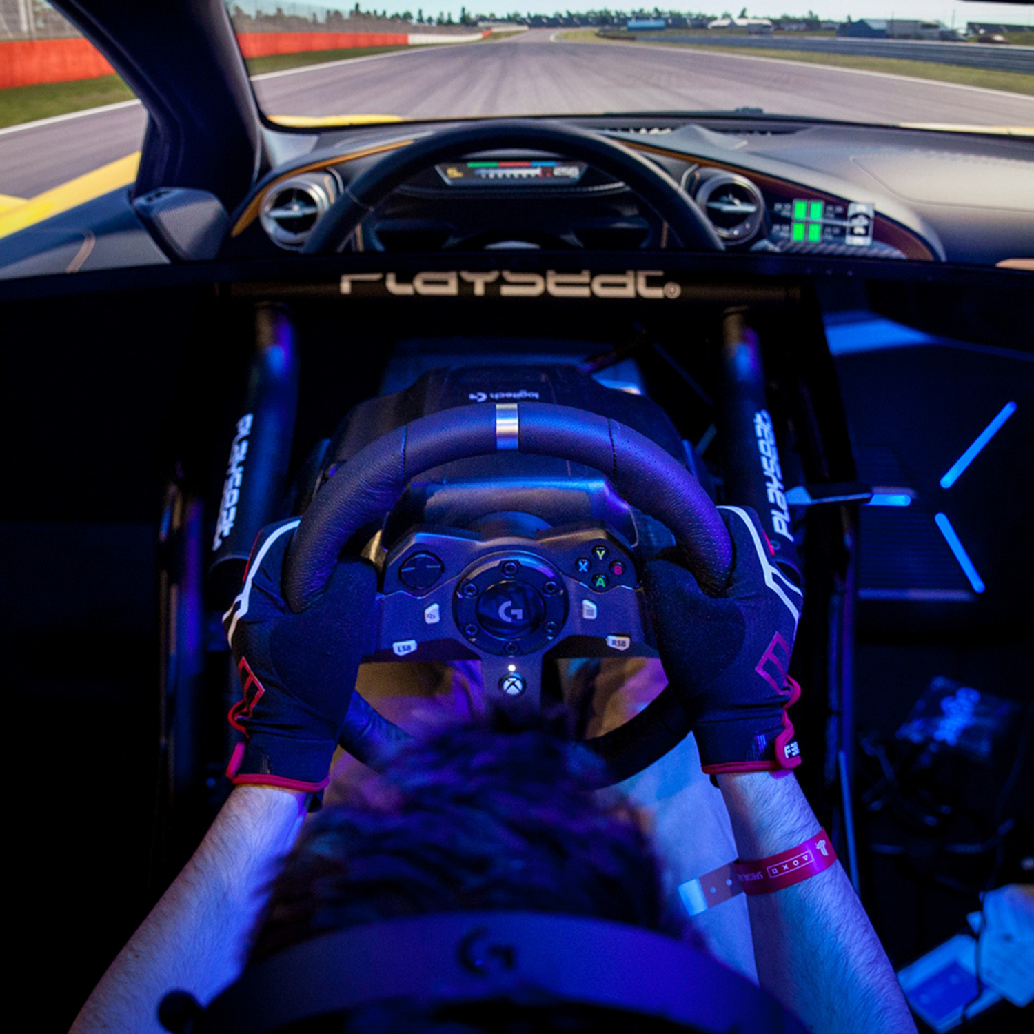 Persona en un simulador de carreras, manos en el volante.