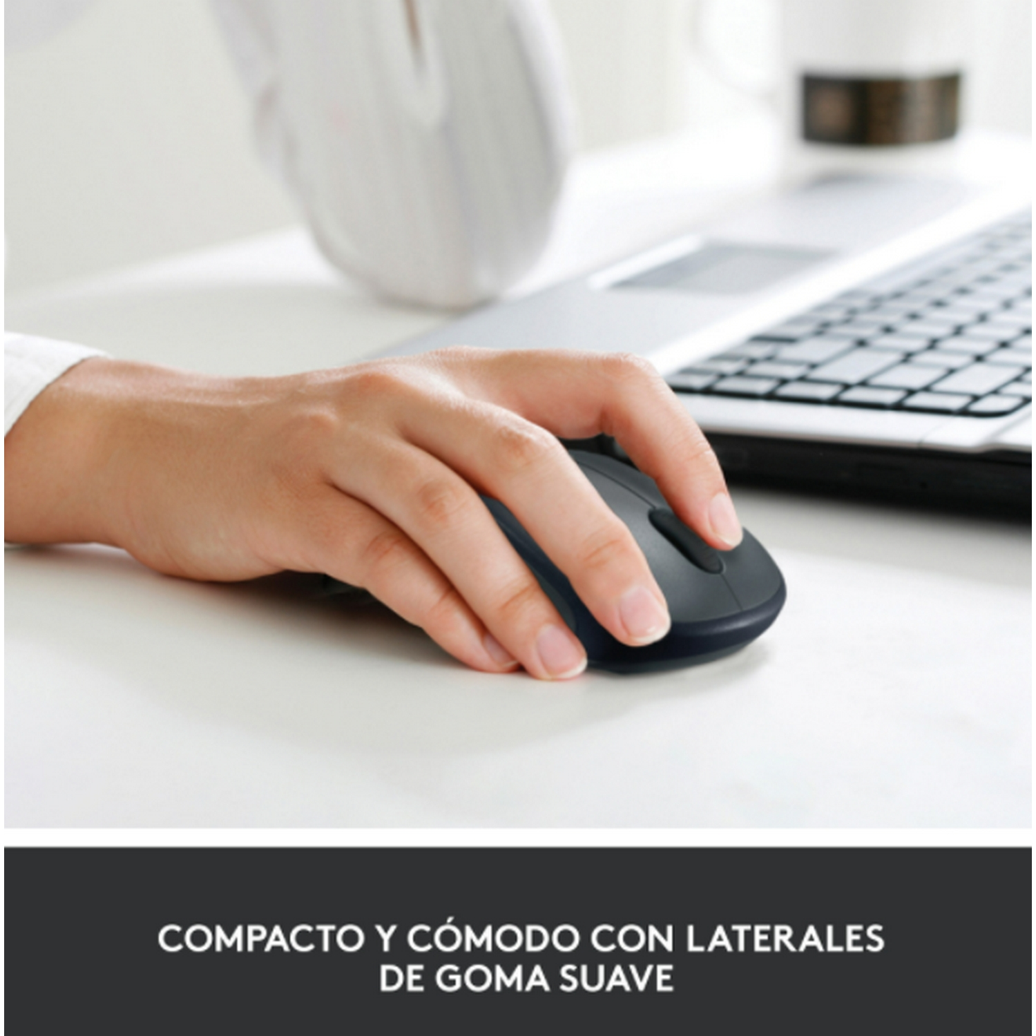 Mano de persona usando un ratón negro en un escritorio. El ratón tiene laterales de goma suave.