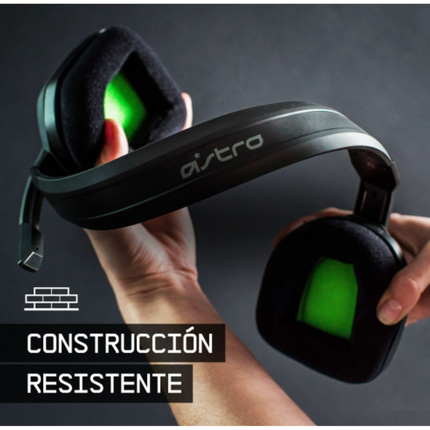 Auriculares gaming Astro negros. Manos sosteniendo los auriculares. Copas verdes.