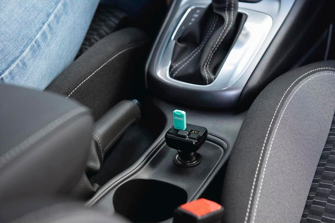 USB charger plugged into a car's power outlet, with a turquoise USB port.