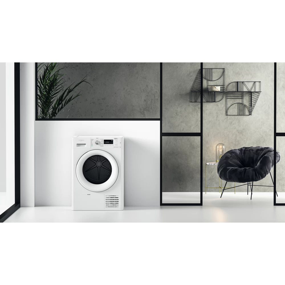 Een witte wasmachine in een kamer met moderne inrichting, dicht bij een raam.