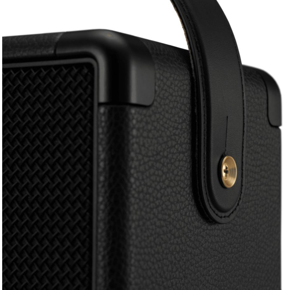 Black speaker with a textured front and a leather handle on top.